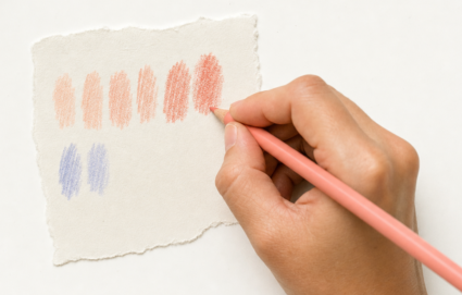 Realistic close-up of a hand holding a salmon-pink colored pencil